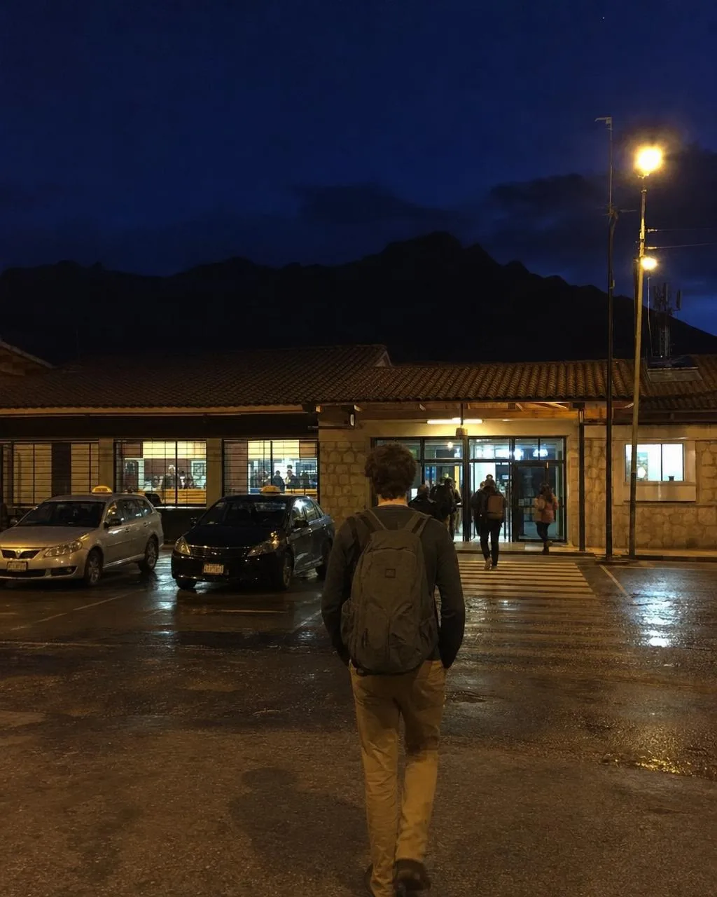 Viajero con mochila ligera llegando al aeropuerto de Cusco de noche